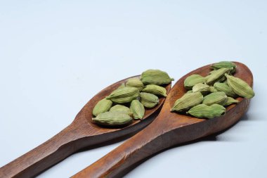 Beyaz arkaplanda izole edilmiş küçük yeşil kardamon tohumu yığını