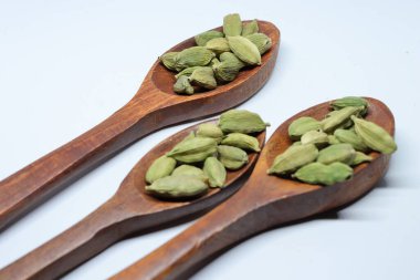 Beyaz arkaplanda izole edilmiş küçük yeşil kardamon tohumu yığını