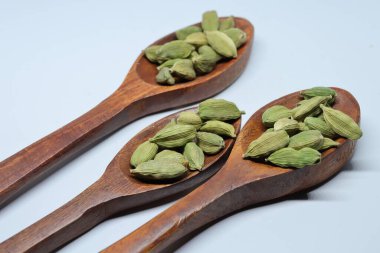 Beyaz arkaplanda izole edilmiş küçük yeşil kardamon tohumu yığını