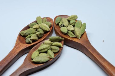 Beyaz arkaplanda izole edilmiş küçük yeşil kardamon tohumu yığını