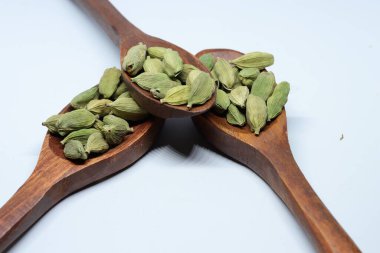 Beyaz arkaplanda izole edilmiş küçük yeşil kardamon tohumu yığını