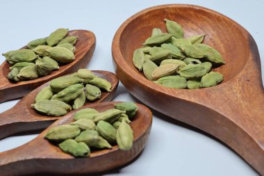 Beyaz arkaplanda izole edilmiş küçük yeşil kardamon tohumu yığını