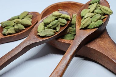 Beyaz arkaplanda izole edilmiş küçük yeşil kardamon tohumu yığını