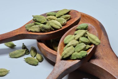 Beyaz arkaplanda izole edilmiş küçük yeşil kardamon tohumu yığını