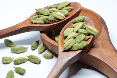 Beyaz arkaplanda izole edilmiş küçük yeşil kardamon tohumu yığını