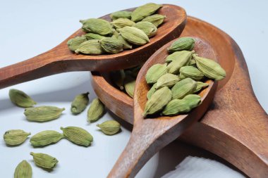 Beyaz arkaplanda izole edilmiş küçük yeşil kardamon tohumu yığını