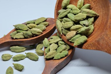 Beyaz arkaplanda izole edilmiş küçük yeşil kardamon tohumu yığını