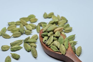 Beyaz arkaplanda izole edilmiş küçük yeşil kardamon tohumu yığını