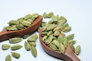 Beyaz arkaplanda izole edilmiş küçük yeşil kardamon tohumu yığını