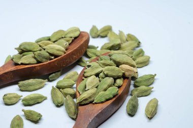 Beyaz arkaplanda izole edilmiş küçük yeşil kardamon tohumu yığını