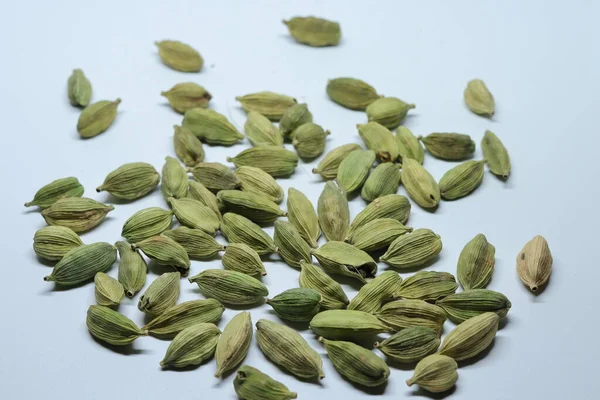 Beyaz arka planda izole edilmiş yeşil kakule tohumları.