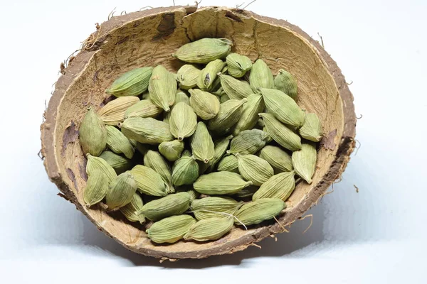 Beyaz arka planda izole edilmiş yeşil kakule tohumları.