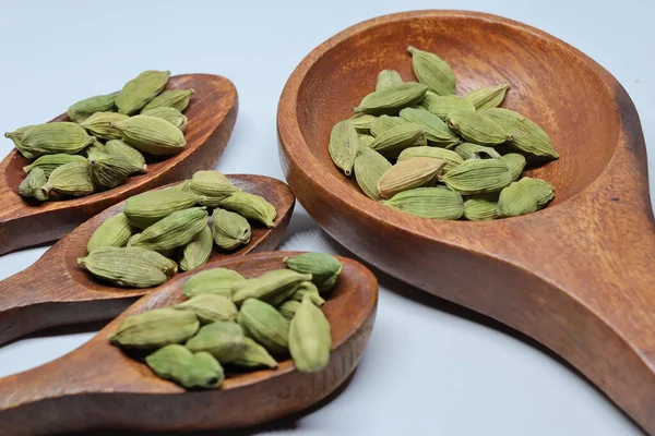 Beyaz arkaplanda izole edilmiş küçük yeşil kardamon tohumu yığını