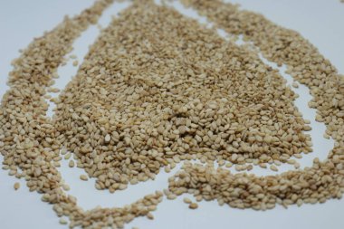 Beyaz arkaplan görünümünde izole edilmiş tahta kaşıkta susam tohumları