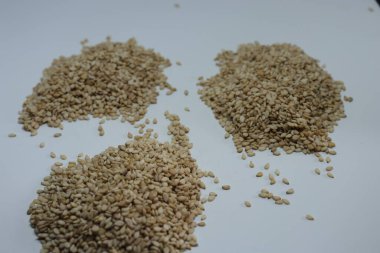 Beyaz zemin üzerinde organik doğal Til Gul veya Susam tohumları