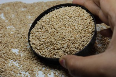 Beyaz zemin üzerinde organik doğal Til Gul veya Susam tohumları