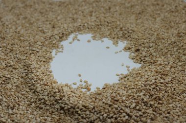 Beyaz zemin üzerinde organik doğal Til Gul veya Susam tohumları