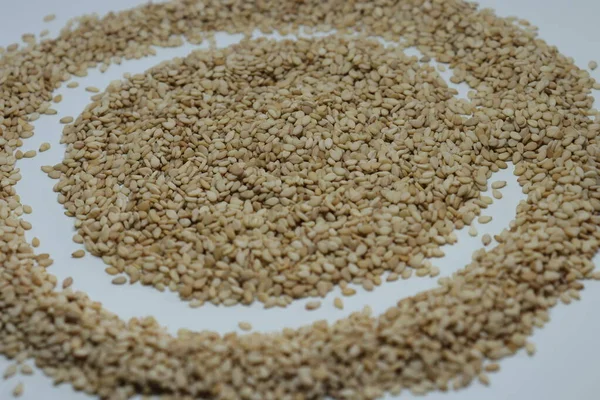 Beyaz arkaplan görünümünde izole edilmiş tahta kaşıkta susam tohumları