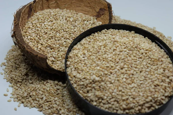 Beyaz zemin üzerinde organik doğal Til Gul veya Susam tohumları