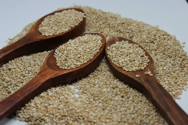 Beyaz zemin üzerinde organik doğal Til Gul veya Susam tohumları