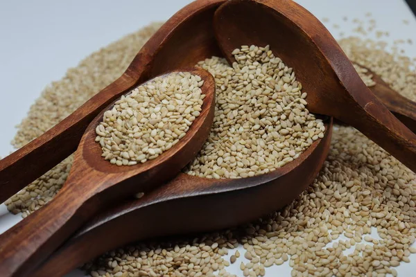 Beyaz zemin üzerinde organik doğal Til Gul veya Susam tohumları