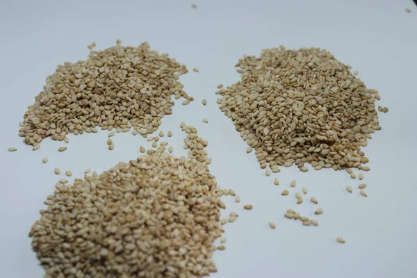 Beyaz zemin üzerinde organik doğal Til Gul veya Susam tohumları