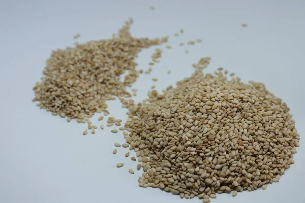 Beyaz zemin üzerinde organik doğal Til Gul veya Susam tohumları