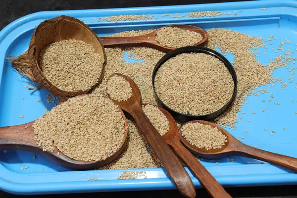 Beyaz zemin üzerinde organik doğal Til Gul veya Susam tohumları