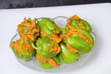 Beyaz arkaplanda bir dilim yeşil dolma biber ya da köri var.