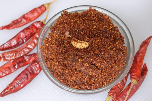 Dry hot red chillies powder on white background from top view