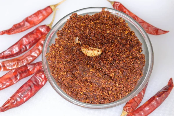 Dry hot red chillies powder on white background from top view