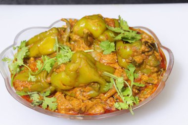 Beyaz arkaplanda bir dilim yeşil dolma biber ya da köri var.