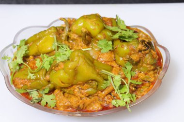 Beyaz arkaplanda bir dilim yeşil dolma biber ya da köri var.