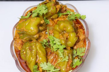 Beyaz arkaplanda bir dilim yeşil dolma biber ya da köri var.