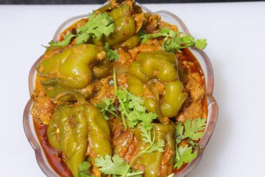 Beyaz arkaplanda bir dilim yeşil dolma biber ya da köri var.