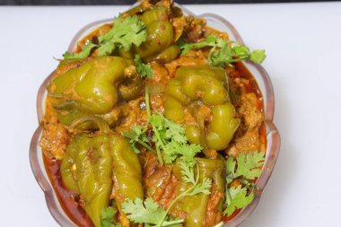 Beyaz arkaplanda bir dilim yeşil dolma biber ya da köri var.