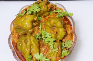 Beyaz arkaplanda bir dilim yeşil dolma biber ya da köri var.