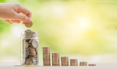 Para biriktirmek için kavanoza para koymak ve tahta panele para yığmak.. 