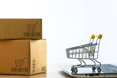 Bir dizüstü bilgisayara konan el arabası ya da tramvay paketin yan tarafını müşterilere teslim etmek için yerleştirmiş. Ticari işlemler internet üzerinden uzaktan satış için yürütüldü.