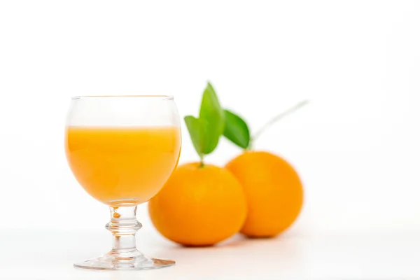 白を基調としたガラスのオレンジジュースと新鮮なオレンジフルーツ — ストック写真