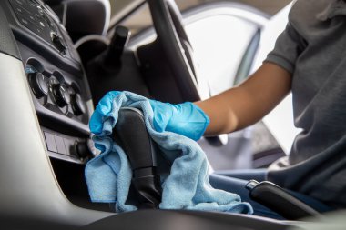 Ellerinde lastik eldiven, vites kolu ya da mikrofiber bezle vites kolu var. Arabanın içini temizle..