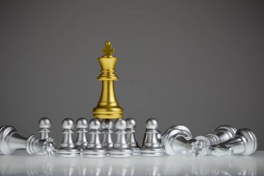 Altın satranç kralı gümüş piyonun üzerinde duruyordu. King oyunu, başarıyı, stratejiyi, zaferi, şah mat 'ı, konsept liderliği ve iş stratejisi planını kazanır..