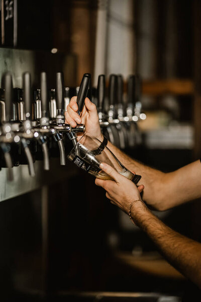 male bartender filling a glass of beer