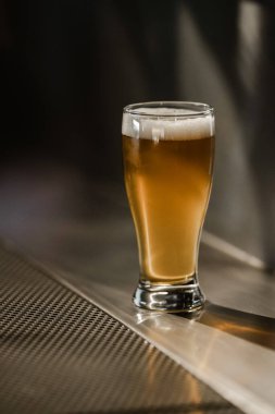 Bar tezgahında tam bir bira bardağı beyaz köpük.