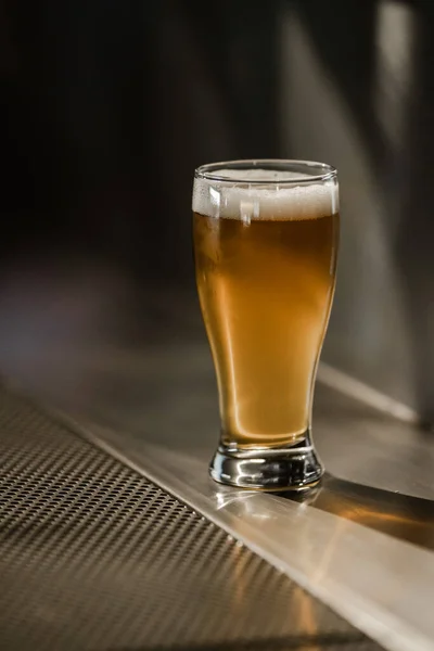 One full beer glass white foam on the bar stand — Stock Photo, Image