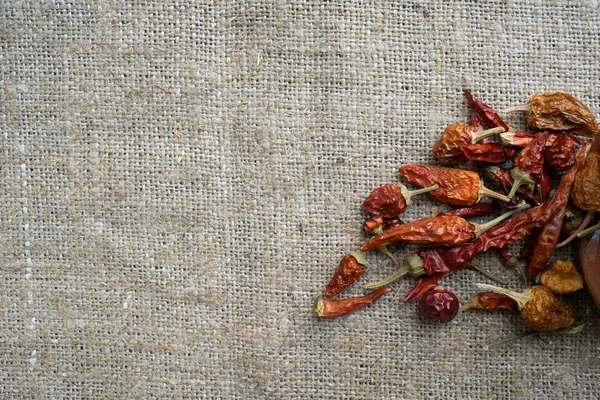 Dry chilli peppers on sackcloth background — Stock Photo, Image