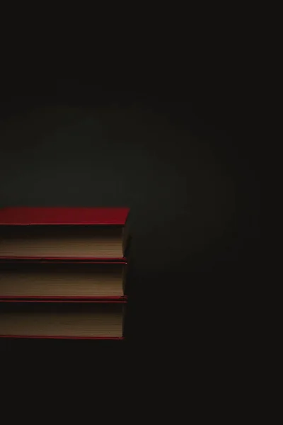 Siyah arkaplan üzerine sarı sayfalı üç eski kırmızı kitap. — Stok fotoğraf