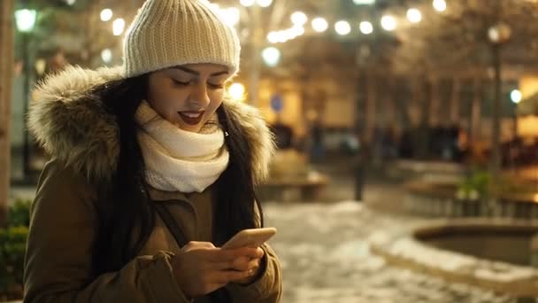 Beautiful Smiling Girl Messaging Smartphone Winter Street Christmas Lights Video — ストック動画