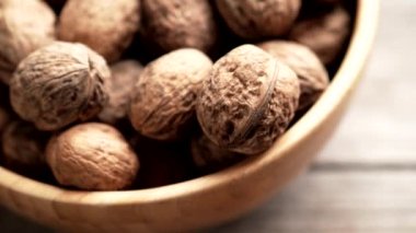 Taze ceviz çekirdekleri ve 4K VIDEO 'daki eski ahşap masada bir kasenin içindeki cevizler. Sağlıklı organik gıda, BIO videoları, doğal arka plan konsepti..