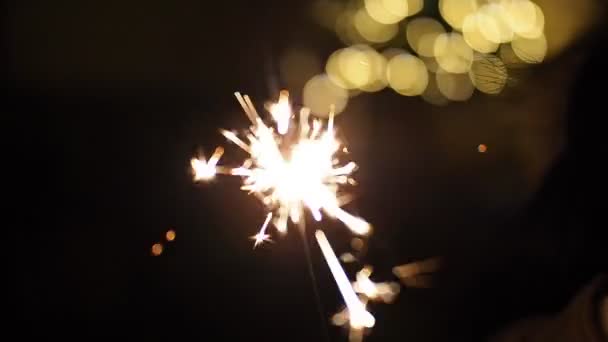 Сжигание Искры Размытыми Рождественскими Огнями Медленном Движении Видео Закрыть Светящиеся — стоковое видео